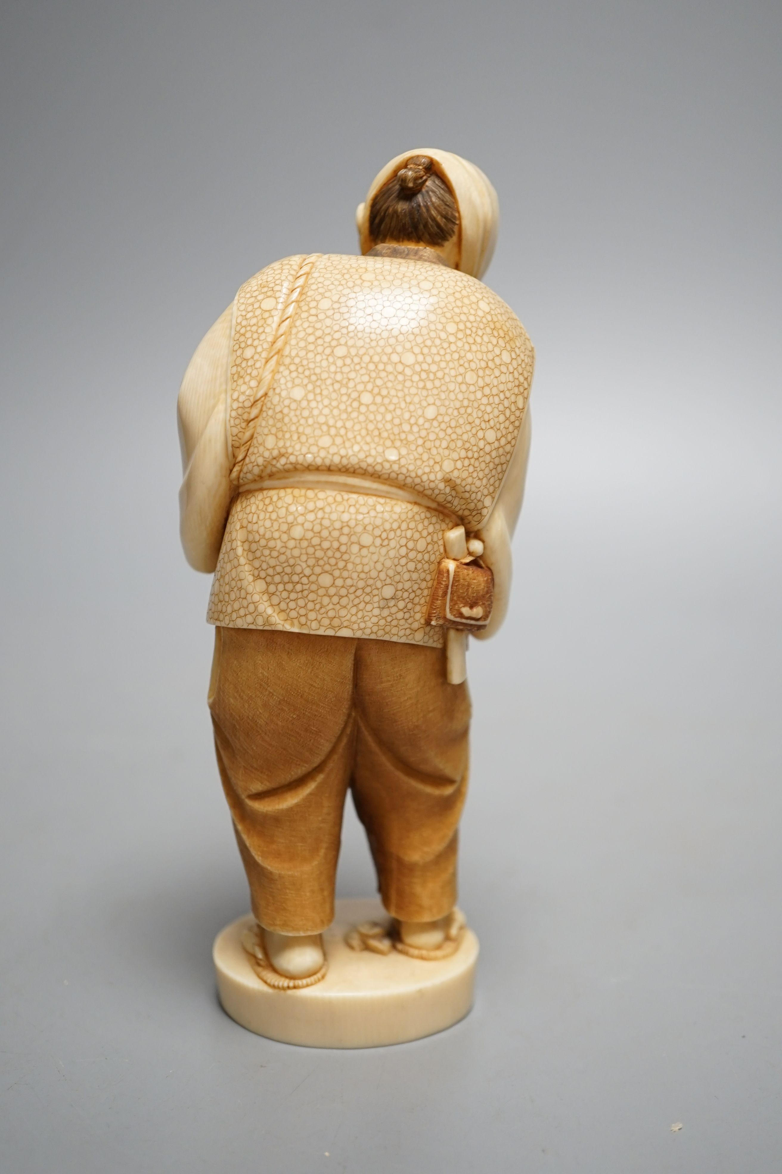 A Japanese ivory figure of a peasant farmer, Taisho/early Showa period, signed to a lacquer tablet - 17cm tall